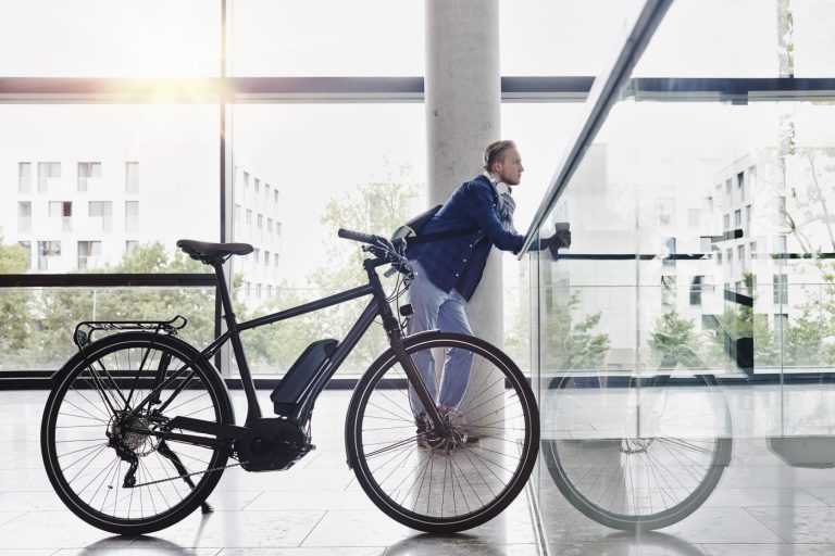 Un etudiant avec un cafe devant un velo a l universite Goethe de Frankfurt