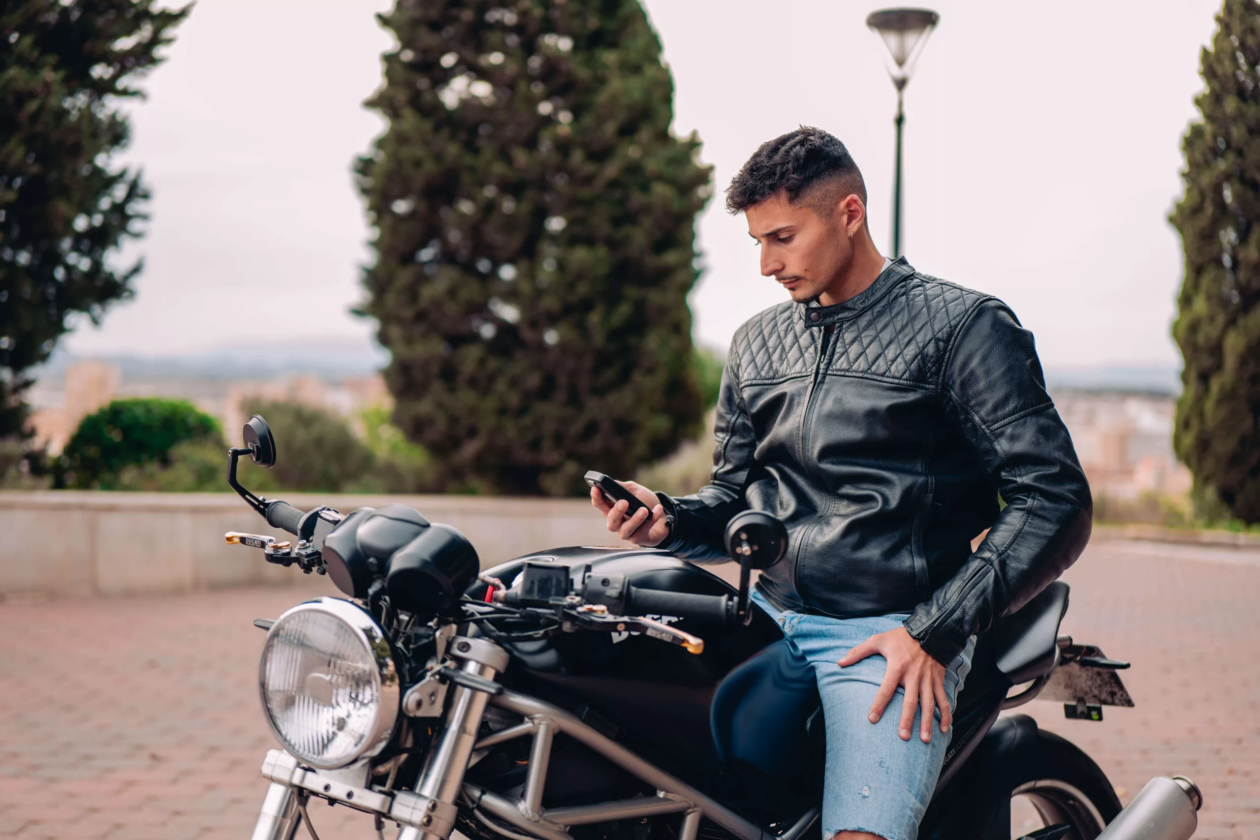 Un homme assit sur sa moto avec un traceur GPS en main